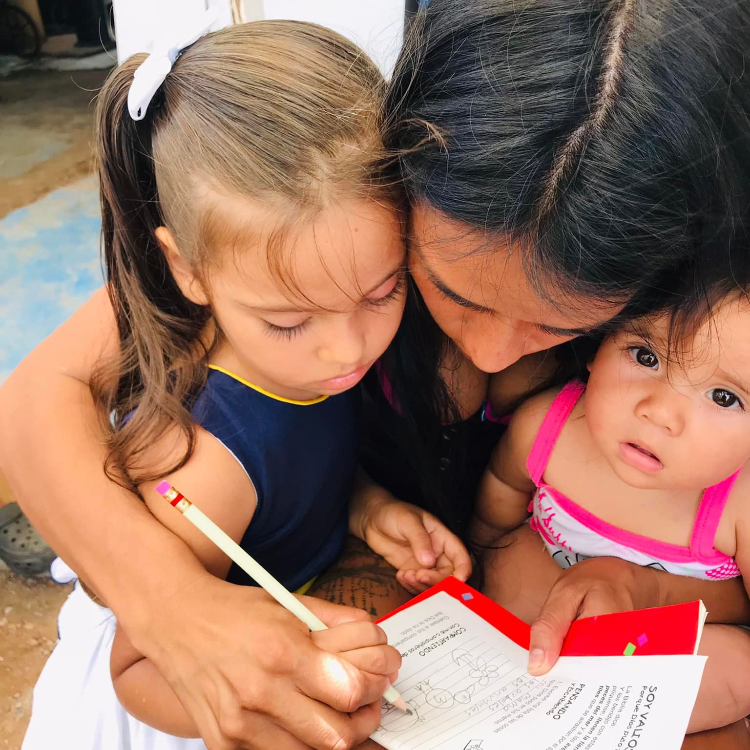 Mamá ayudando a sus hijas con un taller