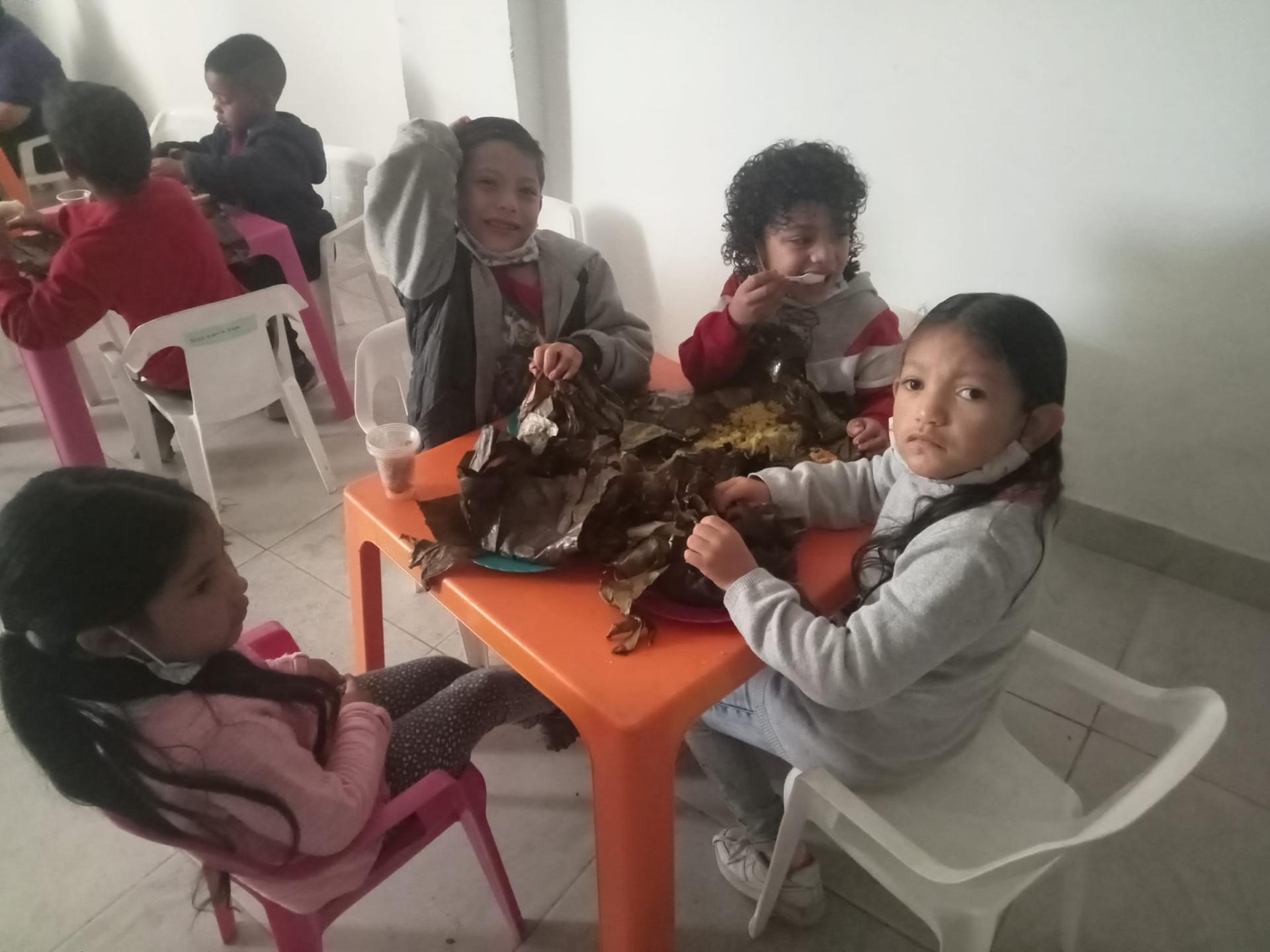 Niños compartiendo tamales en la fundación